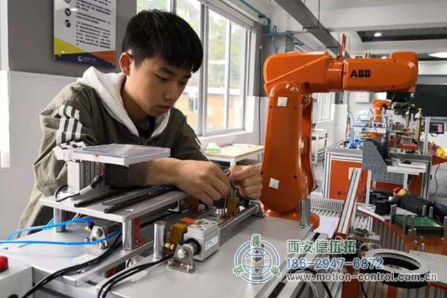 圖為某學生在學習工業(yè)機器人操作的照片 圖為某學生在學習工業(yè)機器人操作的照片